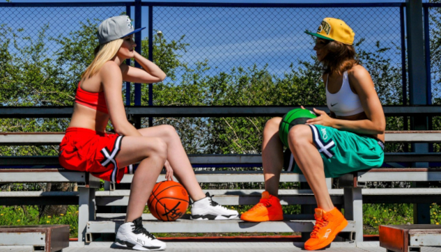 Two women sitting on a bench, one holding a basketball. Image by Sergey Gorbachev from Pixabay.